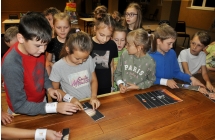 Kilkanaścioro dzieci rozwiązujących zagadkę 
