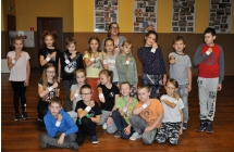 Grupa młodych osób na na tle zdjęć w sali widowiskowej 
