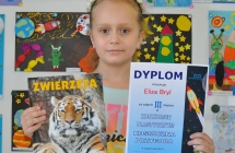 Eliza Bryl laureatka trzeciego mijesca w kategorii dzieci klas 2 na tle prac konkursowych