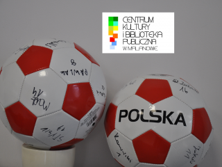 dwie biało-czerwone piłki do gry w nogę z autografami, w tle logo Centrum Kultury i Biblioteki Publicznej w Malanowie