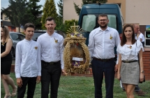 Trzech mezczyzn i kobieta ubrani na galowo z delegacji solectwa Skarzyn Kolonia trzymaja wieniec
