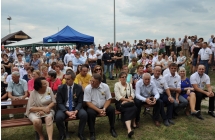 Tłum gosci dożynkowych siedza na ławkach, 