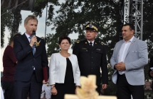 Trzech mężczyzn oraz kobieta na scenie, jeden z mężczyzn przemaiwa do mikrofonu
