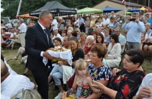 Starosta dożynek częstuje chlebem gości dożynkowych