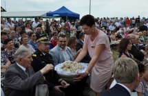 Straościna dożynek częstuje chlebem dożynkowym