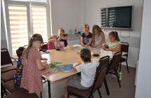 Dziewiecioro dzieci przy stole wykonuje swoje papiery czerpane.