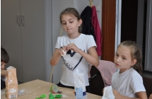 Dwie dziewczynki w bialych bluzkach robia gniotki sensoryczne