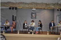 Siedmioro lektrow siedzi przy trzech stolikach 