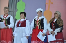 Anna Kłodawska z Jarzębinek na scenie wśród nagrodzonych kobiet z zespołów ludowych.