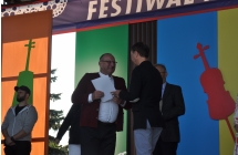 Członek ze społu Łowijowki na sceie odbiera nagrodę z rąk jurorów festiwalu w Kramsku.