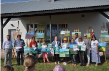 Uczestnicy warsztatów na tle namalnowanych obrazów