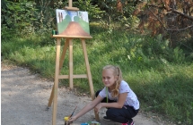 Dziewczynka kuca przy sztaludze
