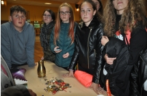 Mlodzi detektywi stoja wokol stolu na ktorym znajduje sie odnaleziony skarb