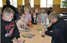 Pan Wieslaw pisze dedykacje w ksiazkach zakupionych przez dzieci