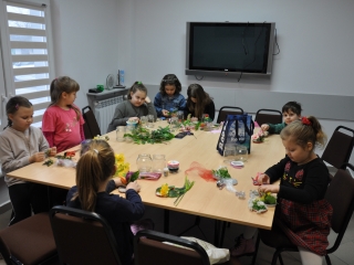 wesole dzieciaczki przygotowujace swoje bukiety ze sztucznych kwiatow