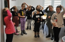 dzieci pokazujace na sobie malpke