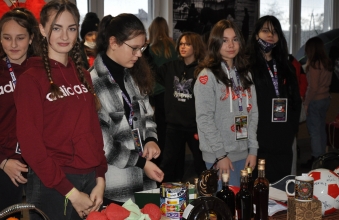usmiechnieci wolontariusze w czasie ogladania przedmiotow kiermaszowych