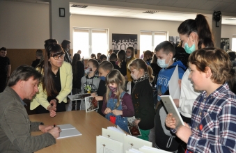 Krzystzof Petekek wpisujacuy dedykacje uczestnikom spotkania