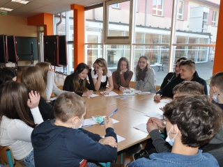 Uczniowie siedza przy stole