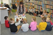 Dzieci podziwiaja trojwymiarowego pieska w ksiazce.