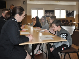 Chlopiec odpowiadajacy na pytania z klas jeden-trzy przed komisja egzaminacyjna