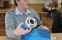 uczestnik OTWP majacy przed soba waz pozarniczy tloczony  z powloka zewnetrzna W75 20m do pomp, motopomp i autopomp