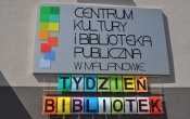 Tablica z logo Centrum Kultury i Biblioteka Publiczna w Malanowie, pod spodem napis tydzien bibliotek