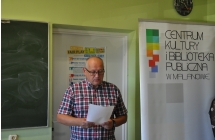 Mezczyzna w okularach czyta z trzymanej w rekach kartki