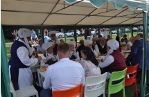 Zespol ludowy spozywajacy posilek przy stole