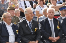 Troje mezczyzn w garniturach oraz jeden w stroju wojskowym