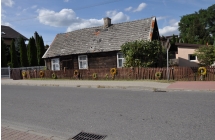 Stary, drewniany dom ustrojony wiencami z kwiatow