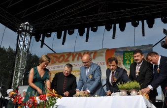 Kobieta wraz z mezczyznami krojaca i ukladajaca chleb 