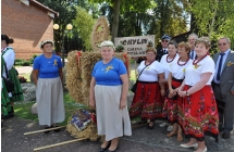 Grupa osob dumnie pozujacych do fotografii przed kosciolem