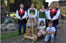 Dzieci i dorosli prezentujacy wieniec dozynkowy Gminy Dobra
