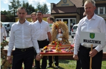 Dozynkowy wieniec z wizerunkiem Jezusa niesiony przez mezczyzn