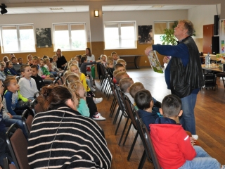 Mezczyzna pokazujacy i opowiadajacy dzieciom