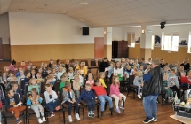 Dzieci  i dorosli sluchajacy wykladu mezczyzny