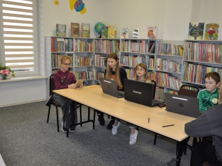 Chlopiec i cztery dziewczyny przy laptopach