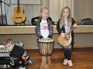 Dwie dziewczynki  i chlopiec przy akordeonie