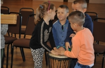 Trzech chlopcow i dziewczynka grajacy na instrumentach