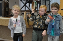 Dziewczynka i dwoch chlopcow na tle instrumentow i sceny