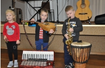 Dziewczynka i dwoje chlopcow z instrumentami muzycznymi