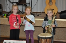 Dwie dziewczynk i chlopiec na tle instrumentow
