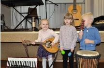 Dwie dziewczynki i chlopczyk grajacy na instrumentach