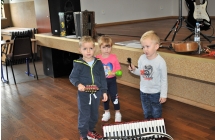 Dwoje chlopcow i dziewczynka z instrumentami na tle sceny