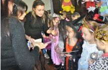 Trzy kobiety rozdajace dzieciom dyplomy