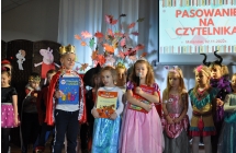 Chlopczyk i dwie dziewczynki pozujace z ksiazkami