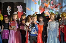 Chlopczyk przebrany za krola na tle sceny z bajkowymi motywami