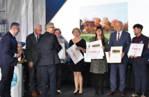 Dwie elegancko ubrane kobiety i piecioro mezczyzn  podczas wreczania nagrod