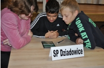 Dwoje chlopcow i dziewczyna skupieni na roziazywaniu zadan